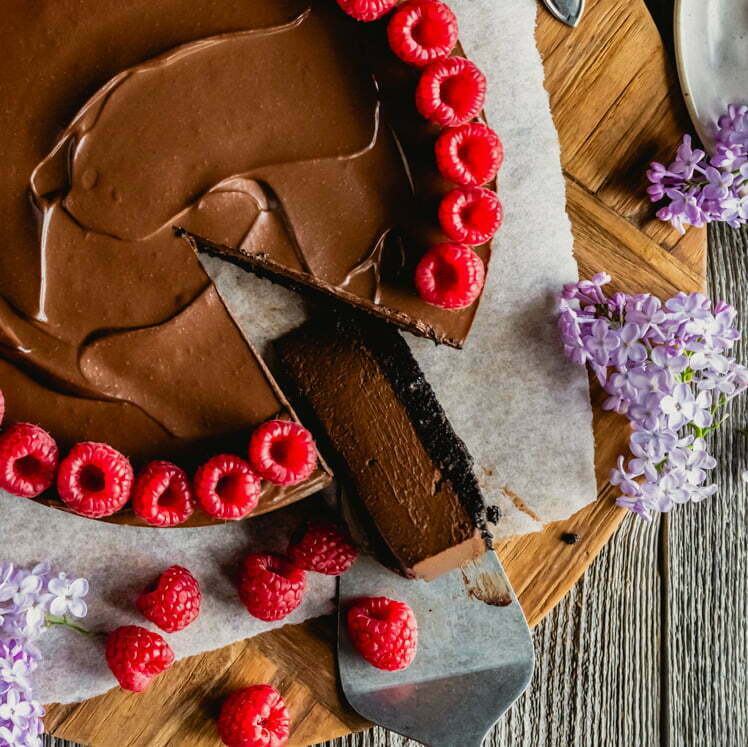 Näyttävä suklaakakku on tehty pehmeästä tofusta ja maapähkinävoista ja koristeltu vadelmilla.