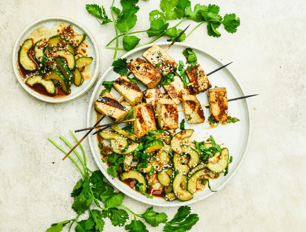 Grillatut tofuvartaat lautasella chili-seesamikurkkujen ja korianterin kera.