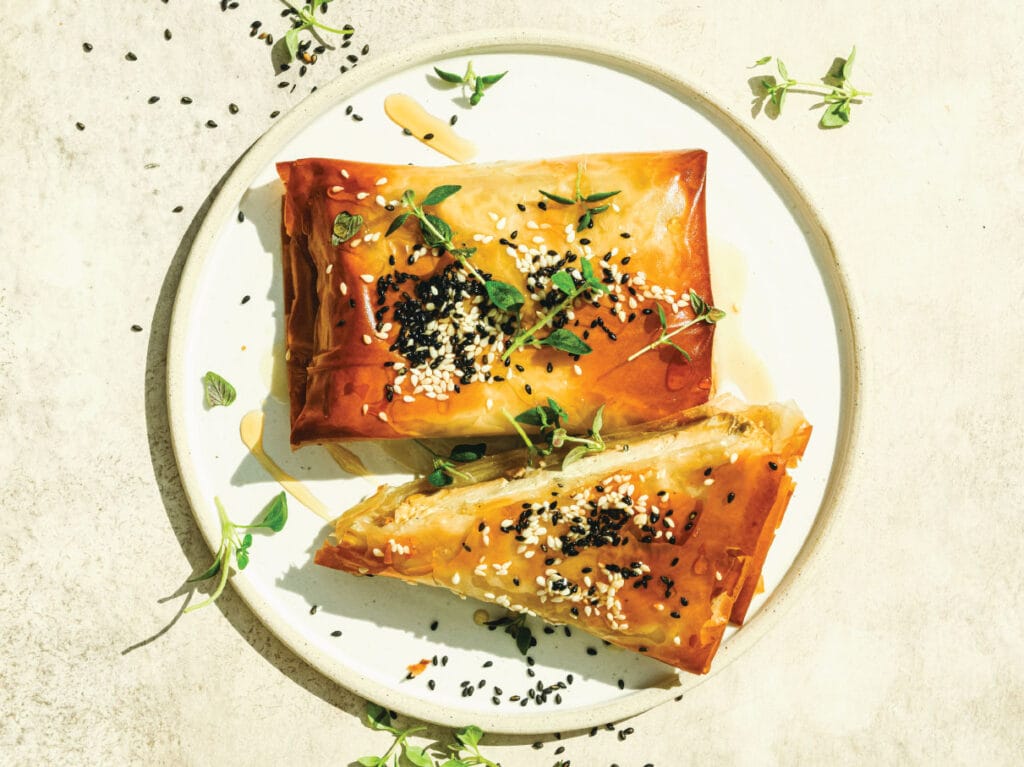 Lautasella rapeat filonyytit savutofutäytteellä, päällä seesaminsiemeniä.