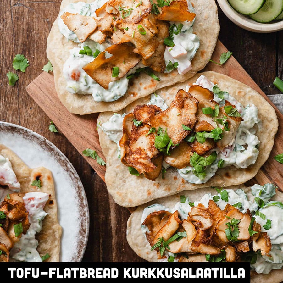 Itsetehty flatbread rapealla kebabtyylisellä tofulastulla leikkuulaudan päällä.