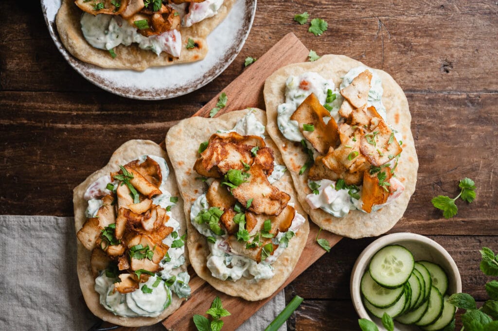 kebabtyylisesti rapeaksi paistettuja tofulastuja flatbreadin päällä ja kurkkusalaattia.
