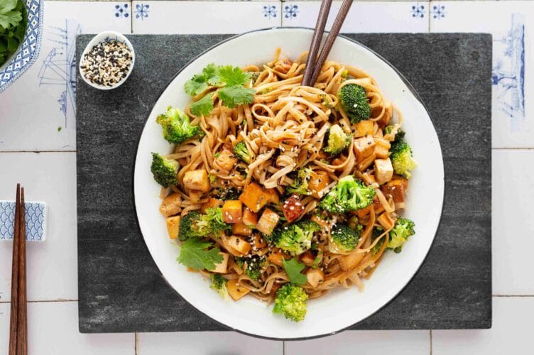 Nopea tofu-teriyakinuudelit lautasella, jossa rapeaa tofua, parsakaalia ja nuudeleita.