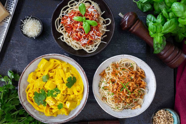 Kolme värikästä ja herkullista tofupastaa lautasilla.