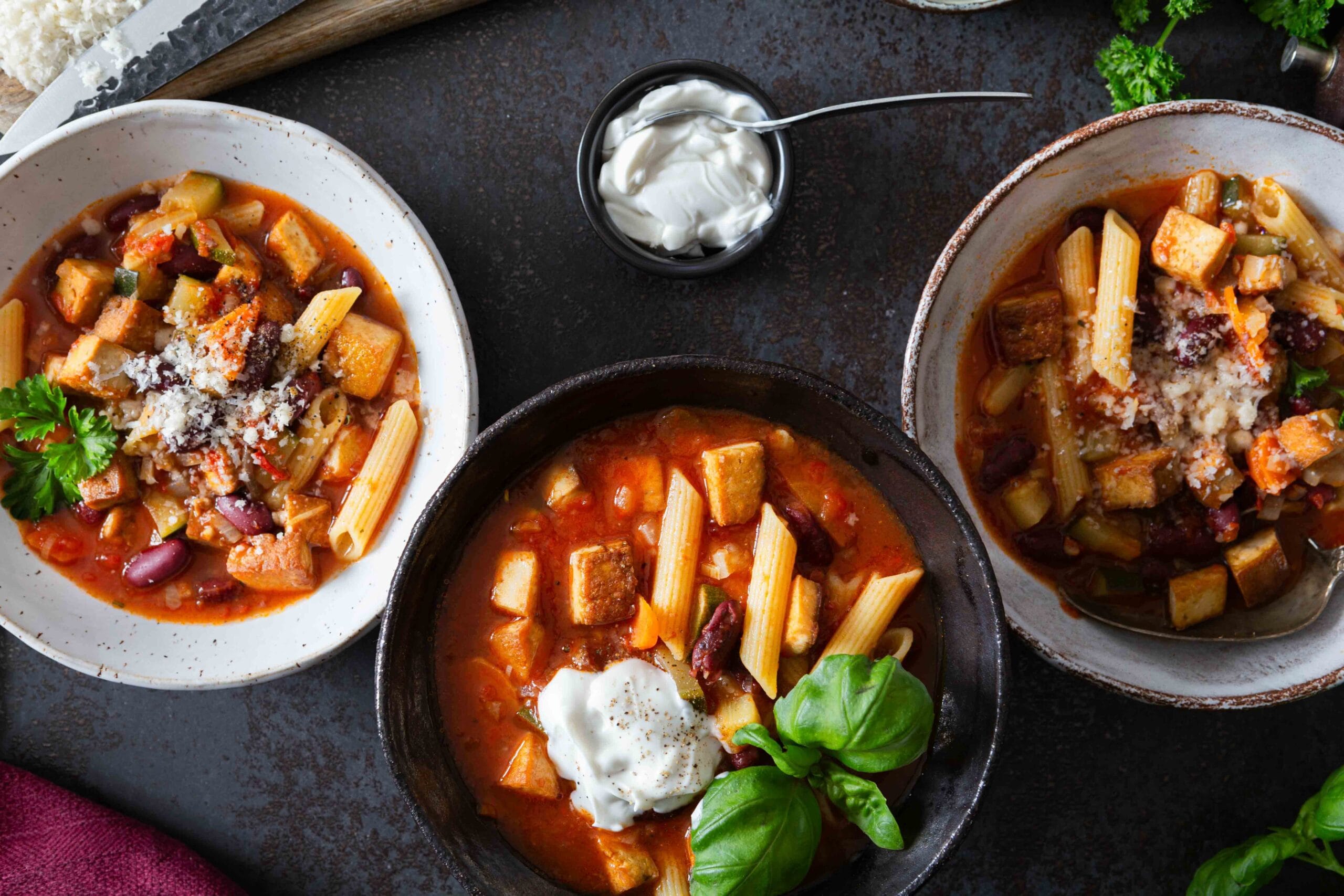 proteiinipitoinen minestrone-savutofukeitto kolmella lautasella.